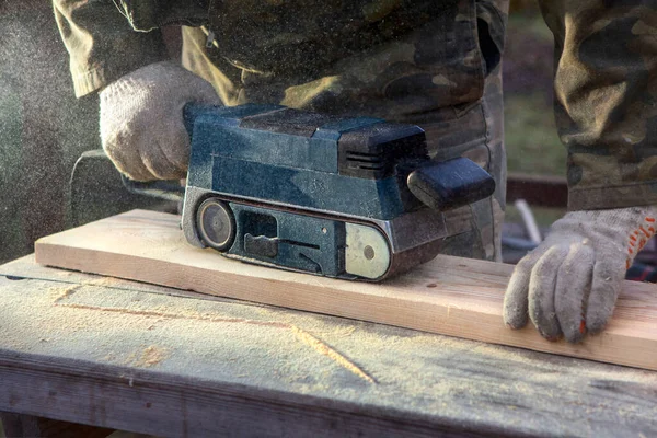 带磨床的接线员的手飞剪 一个专业人员的工作木制品 — 图库照片
