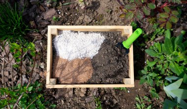 Toprak karışımının bileşenleri: biyo gübreler, toprak katkı maddeleri ve bahçedeki ahşap bir kutuda sebze yetiştirmek için geliştirmeler. Vermicompost, vermikülit, biyohumus, ahşap bir sandıkta agroperlit..