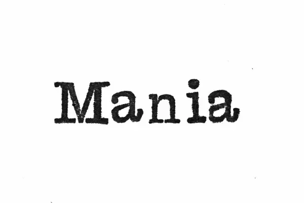 A palavra "Mania" de uma máquina de escrever em branco — Fotografia de Stock