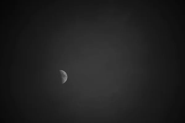 Karanlık bir arka plan üzerinde belli belirsiz ışıklı bir ay — Stok fotoğraf