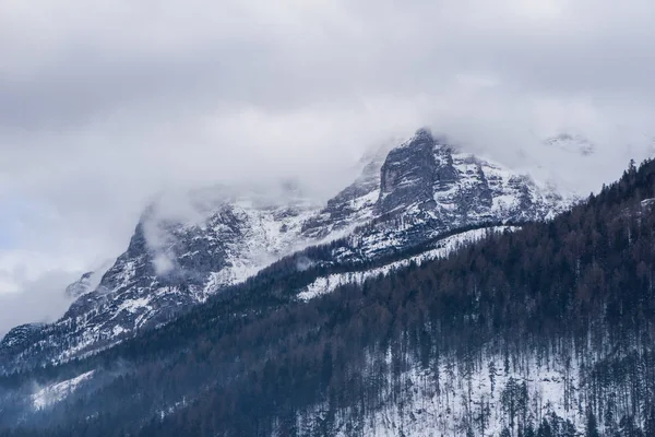 Escena épica de montaña con espectaculares picos cubiertos de nieve atravesando las nubes — Foto de Stock