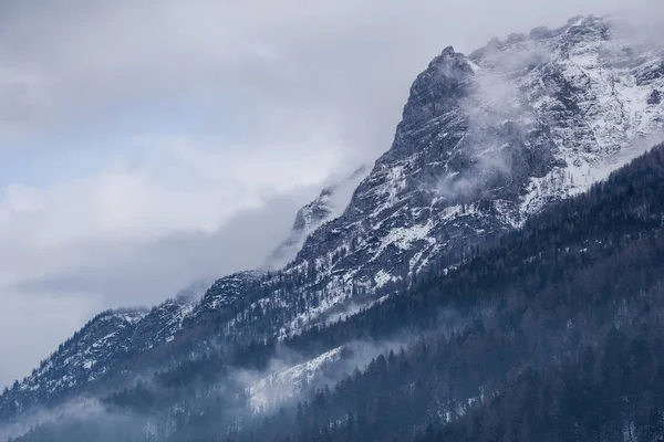 Nebel wälzt sich die Seite eines Berges hinunter und schafft eine dramatische Szene Stockbild