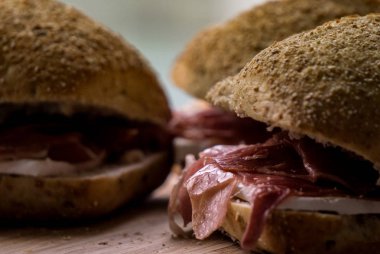 Tam tahıllı ekmek, Parma jambonu ve camembert peynirinden yapılmış sandviçi kapat.