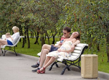 Moskova, Rusya - 25 Ağustos 2018: Genç bir adam ve hamile bir kadın bir şehir parkında bir bankta birlikte oturuyorlar