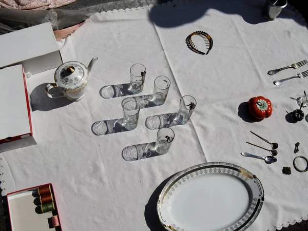 Tableware, table items and household items in the sunlight spread out on the tablecloth