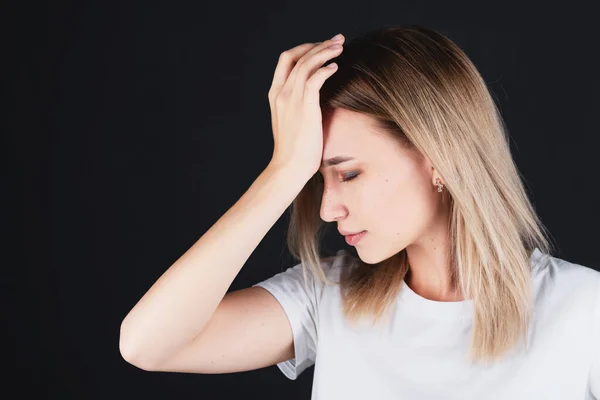 Emotional portrait of a girl holding her head in her hands, feeling pain. — Stock Photo, Image