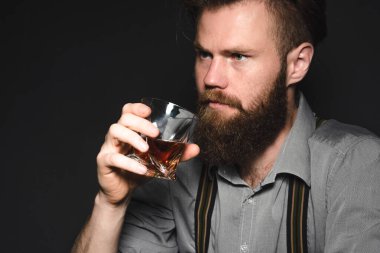 Sakallı ve bardaktan alkol içen yakışıklı bir gencin portresi..