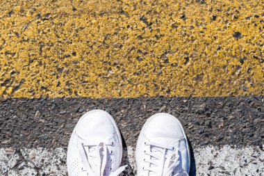 İşaretli yaya geçidinden geçen bir yayanın alçak kesimi.