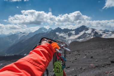 Dağlarda tırmanma ekipmanlarıyla birinci şahıs görüntüsü. Dağ tırmanışı