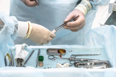 Diş aletleri ve cerrahi şablonla implantasyonda olan bir dişçi cerrahının ellerinin yakın çekimi.