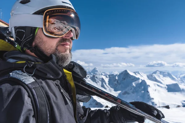 Un uomo con gli sci si erge in cima alle montagne godendo il paesaggio. Sci alpino, estremo relax — Foto Stock