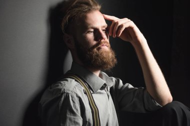 İzole edilmiş siyah bir arka planda, düşünceli, yakışıklı bir gencin portresi..