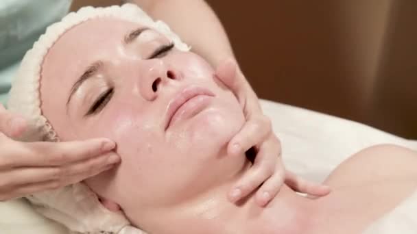 Gezondheid, schoonheid, resort en ontspanning concept - mooie vrouw in spa salon gezicht behandeling krijgt — Stockvideo