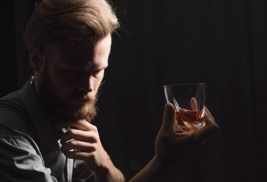 Elinde bir bardak alkolle dalgın ve yakışıklı bir gencin portresi..