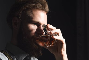 Elinde bir bardak alkolle dalgın ve yakışıklı bir gencin portresi..