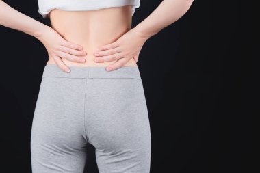 Bir kız belini tutar, arkadan bakar..