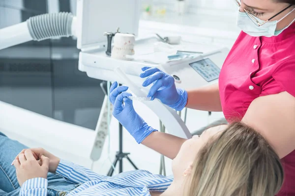 Médico dentista femenino sostiene protector bucal dental en las manos, terapia de férula en odontología para corregir la mordedura — Foto de Stock