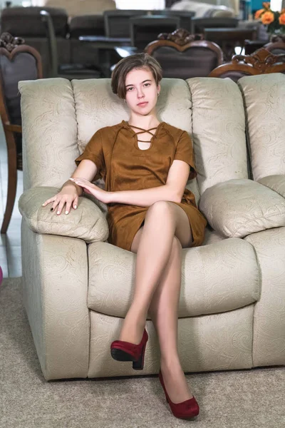 Portrait of a beautiful young girl who is sitting in a beautiful expensive chair — Stock Photo, Image