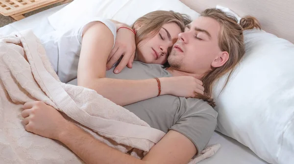 Belo casal encontra-se abraçando na cama, vida juntos, relacionamento em um par — Fotografia de Stock