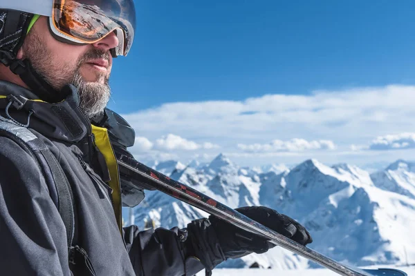 Um homem com esquis fica no alto das montanhas apreciando a paisagem. Desça esqui, relaxamento extremo — Fotografia de Stock
