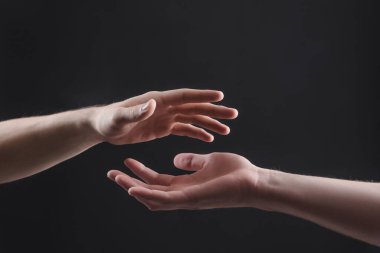 Gri arkaplandaki iki erkek elinin dokunuşu, insanlar arasındaki ilişki kavramı.