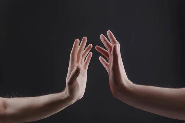 El toque de dos manos masculinas sobre un fondo gris, el concepto de la relación entre las personas — Foto de Stock