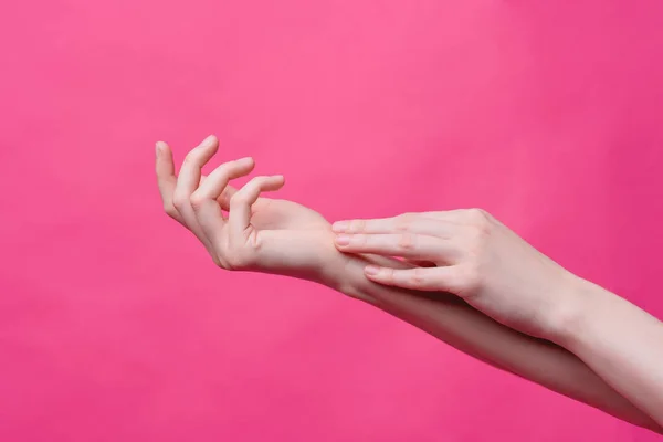 Lindas, jovens mãos femininas em um fundo rosa. Higiene, frescura e conceito de cuidados com a pele, mãos de um massagista ou cosmetologista, indústria de salões de beleza e spas — Fotografia de Stock