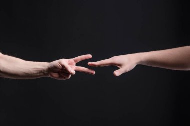 Erkekler karanlık arka planda, taş, makas, kağıt oynuyorlar. Yüzleşme ve rekabet kavramı, oyunlar