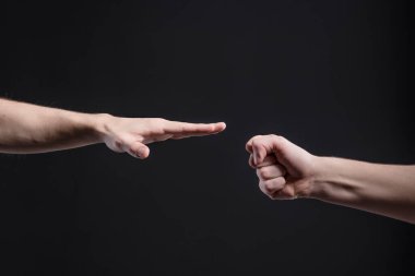 Erkekler karanlık arka planda, taş, makas, kağıt oynuyorlar. Yüzleşme ve rekabet kavramı, oyunlar