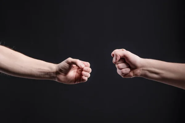 Mens mãos sobre um fundo escuro, mostrar um jogo de pedra, tesoura, papel. O conceito de confronto e rivalidade, jogos — Fotografia de Stock