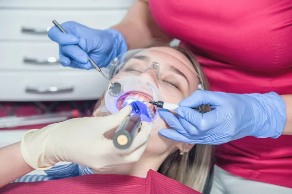 A dentist examines a patient, close-up of a patient with an open mouth next to which dental objects. The concept of health care and treatment in medical facilities