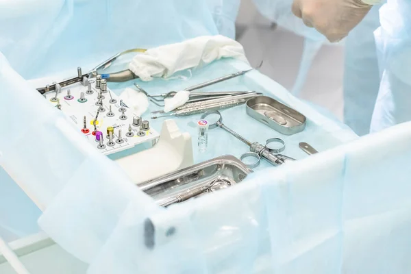 Close-up das mãos de um dentista e enfermeiro cirurgião sobre uma sala de cirurgia durante uma operação de implante dentário — Fotografia de Stock