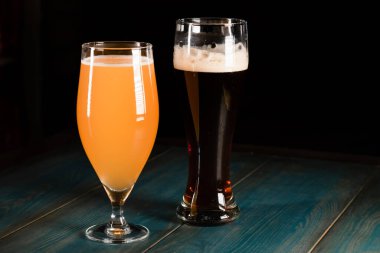 Tahta bir masanın arka planına bira döktü. Rahatlama ve eğlence kavramı.