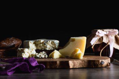 Masanın üzerindeki tahta tezgahta peynir ve ekmek. Arka planda. Beslenme ve güzel yemek servisi kavramı..