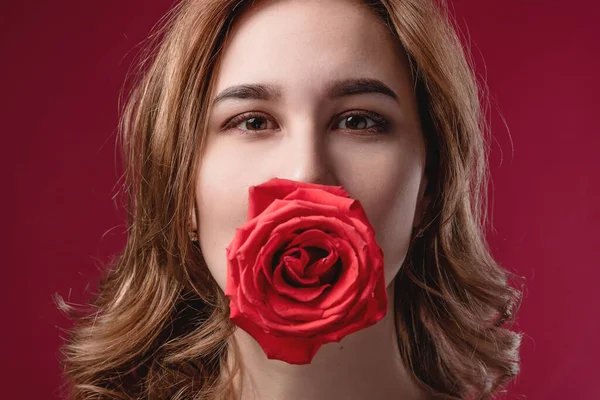 Retrato de uma menina bonita com ombros nus e uma rosa. O conceito de juventude, beleza e um corpo saudável — Fotografia de Stock