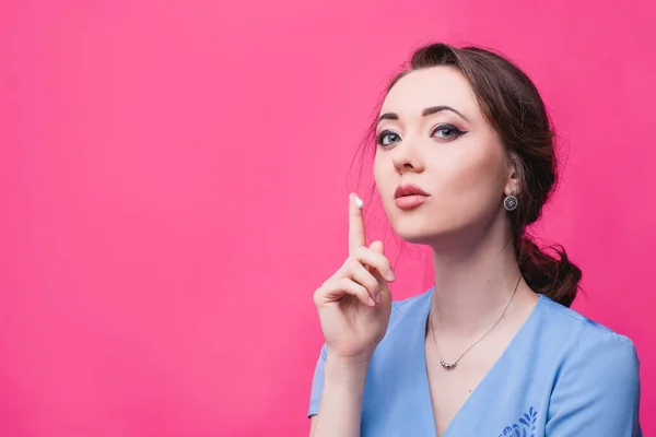 Girl puts cream on her hands on a pink background. The concept of skin care. — Stock Photo, Image