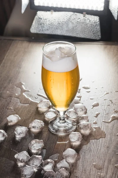 Auf dem Tisch steht ein Glas leichtes Bier mit Eis. Das Konzept der Entspannung, Bars und Partys — Stockfoto