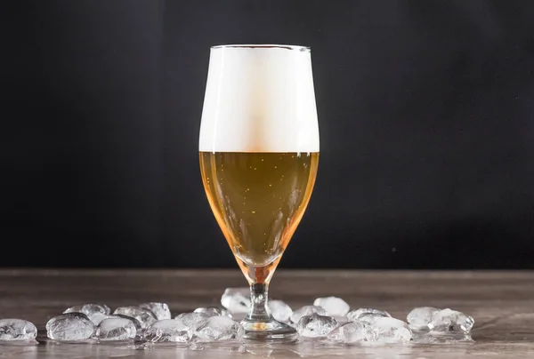 Auf dem Tisch steht ein Glas leichtes Bier mit Eis. Das Konzept der Entspannung, Bars und Partys — Stockfoto