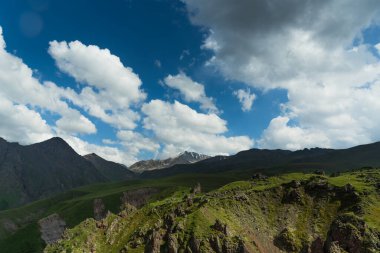 Dağlardaki yaz manzarası ve bulutlu koyu mavi gökyüzü.