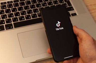 Moskova / Rusya - 18 Mayıs 2020: Macbook arkaplanda siyah iPhone 11 profesyonel. Ekranda, TikTok uygulaması.