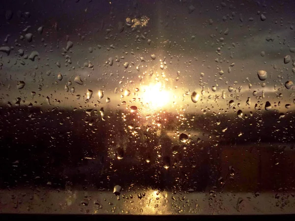Gotas de lluvia en ventana y puesta de sol — Foto de Stock