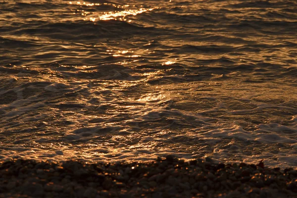 日落海滩背景。 在夕阳的余晖中，海浪汹涌而过。 夕阳西下的海浪和迷人的海景 — 图库照片