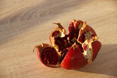 Masanın üzerinde olgun, sulu nar meyvesi var. Meyve dilimlenir.