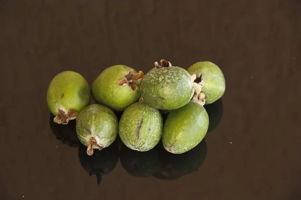 Fresh fruits of feijoa on a glass table with a reflection — Stock Photo, Image