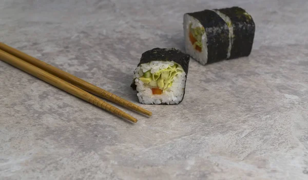 Närbild sushi rullar med ätpinnar på bordet. Japansk mat. — Stockfoto