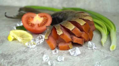 Masada iştah açıcı füme balık. Mezeye buz parçalarıyla süslenmiş domates ve soğan ekleniyor.. 