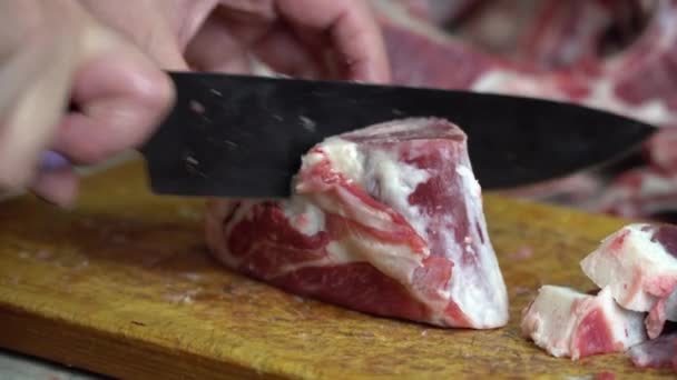 Com uma faca afiada em uma placa de madeira cortar a carne de cordeiro gorda — Vídeo de Stock