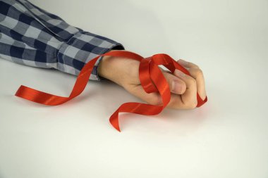 Beyaz arka planda bir adamın elinde kırmızı kurdele.