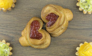 Tahta bir arka planda, kalp şeklinde çörekler.