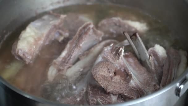 Viande juteuse dans une casserole bouillante sur la cuisinière — Video